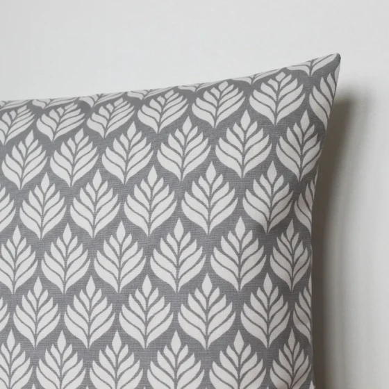 A grey and white cushion cover featuring a simple small scale floral pattern