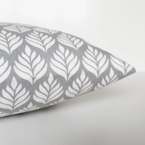 A grey and white cushion cover featuring a simple small scale floral pattern