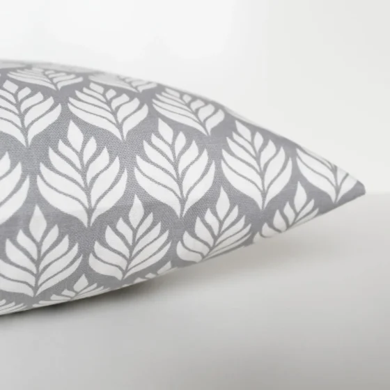 A grey and white cushion cover featuring a simple small scale floral pattern